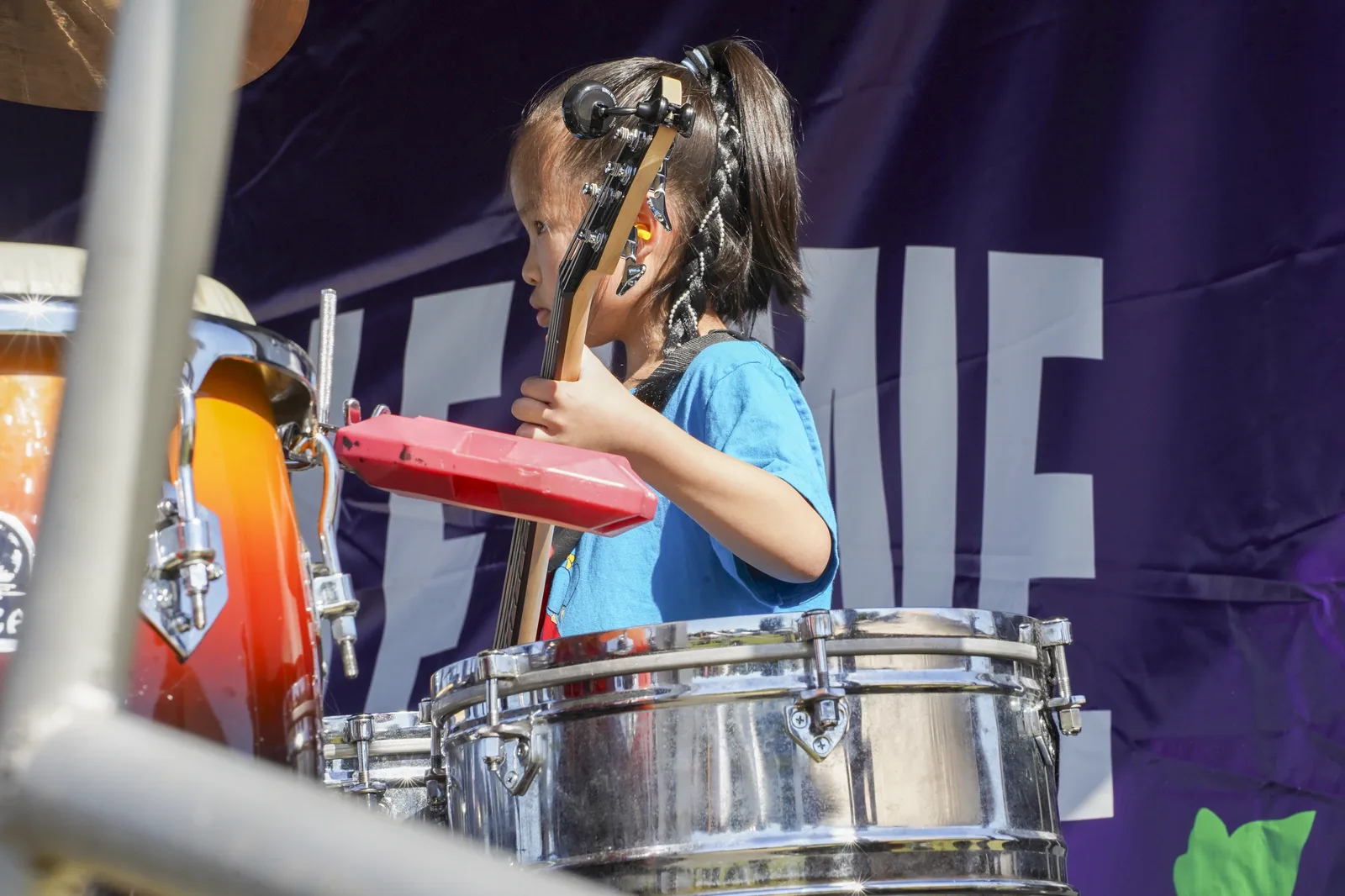 A young We Got The Beat musician performing on bass guitar.